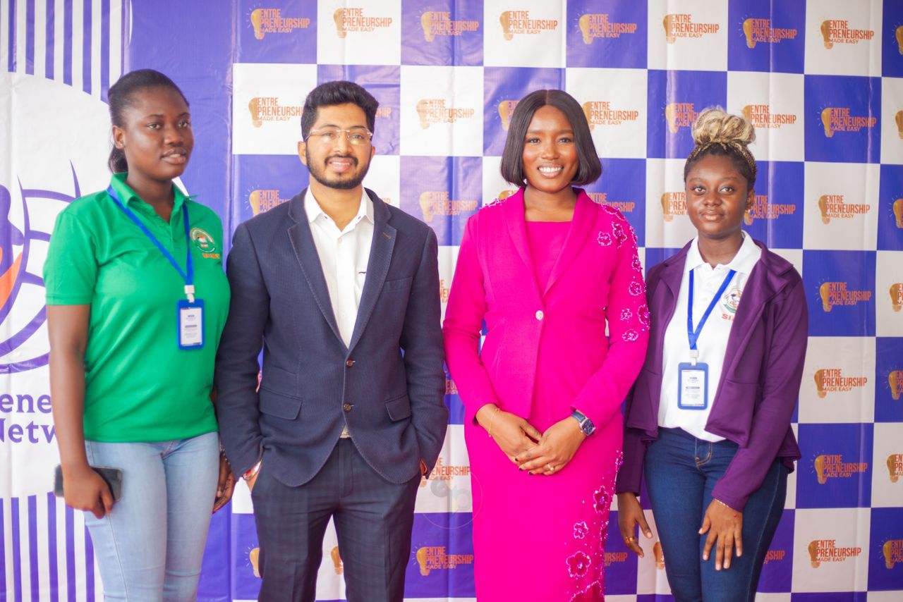 Four attendees posing in front of the event backdrop at the EME Summit 2025