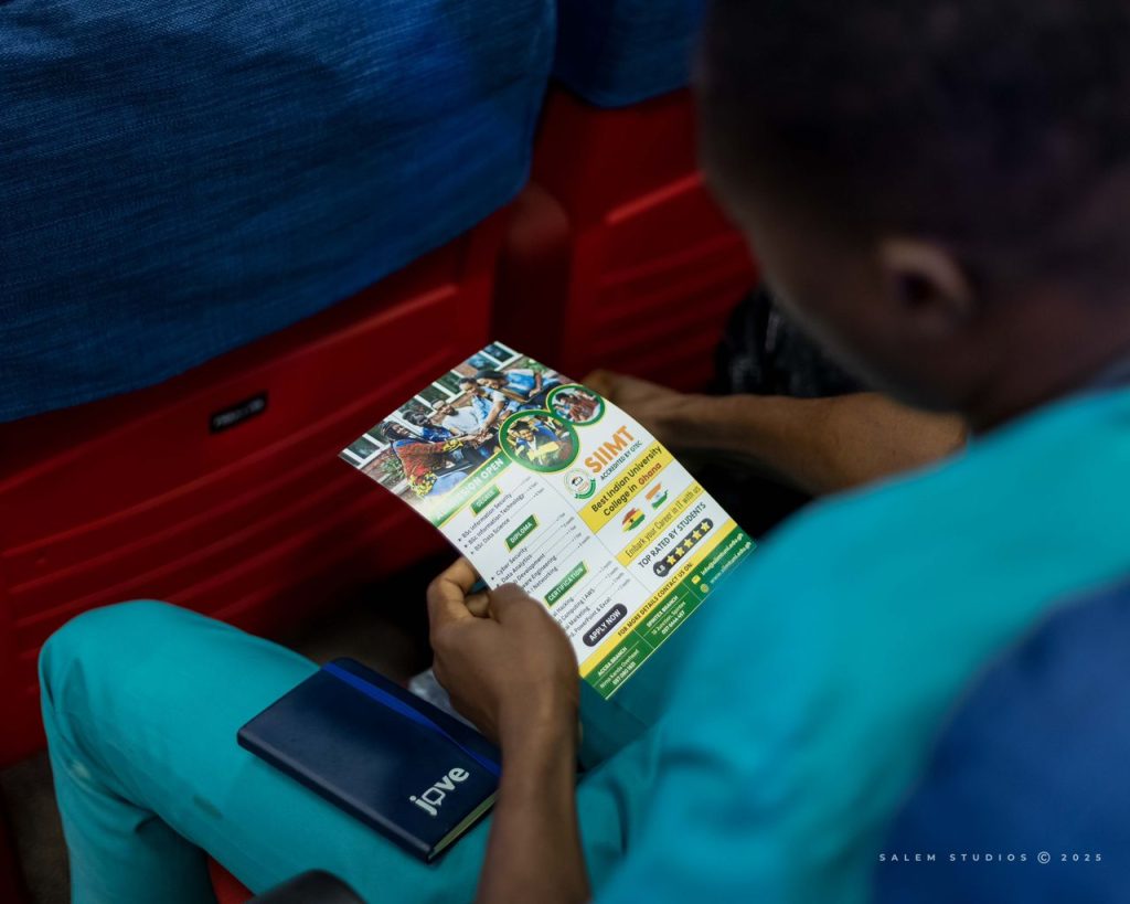 A participant reading an event flyer at the EME Summit 2025