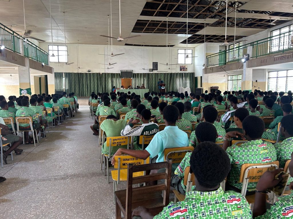 Rows of students in green uniforms seated in the hall at the SIIMT orientation at Nungua SHS