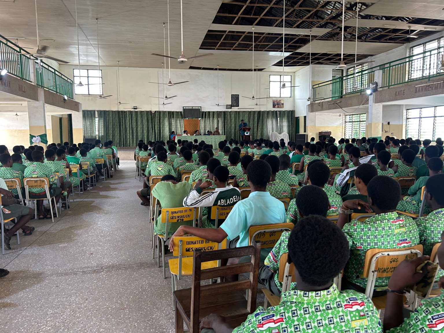 Rows of students in green uniforms seated in the hall at the SIIMT orientation at Nungua SHS